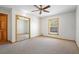 Bedroom with carpet, closet with mirror doors, a window, and a ceiling fan at 1889 Eden Dr, Deltona, FL 32725