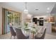 Dining area with glass table set on tile flooring with bright kitchen in background at 1889 Eden Dr, Deltona, FL 32725