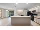 Kitchen featuring white cabinets, black appliances, tile flooring, island, and glass doors at 1889 Eden Dr, Deltona, FL 32725