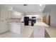 Well-lit kitchen with white cabinets, black appliances, tile flooring, and an island at 1889 Eden Dr, Deltona, FL 32725