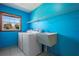 A well-lit laundry room featuring a utility sink, washer, dryer, and tile flooring at 1889 Eden Dr, Deltona, FL 32725