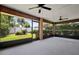 Screened-in patio with ceiling fans, concrete flooring and partial view of back yard at 1889 Eden Dr, Deltona, FL 32725