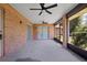 Screened-in patio with ceiling fans, concrete flooring and partial view of back yard at 1889 Eden Dr, Deltona, FL 32725