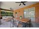 Covered patio with ceiling fans, brick accents, and outdoor dining furniture at 1889 Eden Dr, Deltona, FL 32725