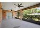 Screened-in patio with ceiling fans, concrete flooring and partial view of back yard at 1889 Eden Dr, Deltona, FL 32725