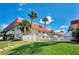 Exterior building with pool, red roof, palm trees, and lush landscaping at 2901 N Halifax Ave # 220, Daytona Beach, FL 32118