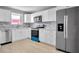 Modern kitchen with stainless steel appliances, white cabinets, and tile backsplash at 2901 N Halifax Ave # 220, Daytona Beach, FL 32118