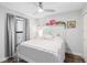 Bright bedroom with white furniture, wood floors, a ceiling fan, and a large window with gray curtains at 2912 Plaza Terrace Dr # 2912, Orlando, FL 32803