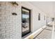 Condo entrance with a glass paneled door, white brick, and hallway view at 2912 Plaza Terrace Dr # 2912, Orlando, FL 32803