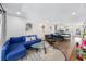 Open living room featuring a blue sofa, modern decor, and hardwood floors leading to the dining area at 2912 Plaza Terrace Dr # 2912, Orlando, FL 32803