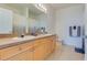 Bright bathroom featuring double vanity, large mirror, and neutral finishes creating a clean and functional space at 305 Terrace Ridge Cir # 305, Davenport, FL 33896
