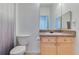 Clean bathroom featuring a vanity with ample storage space, complemented by a toilet and shower, offering practicality at 305 Terrace Ridge Cir # 305, Davenport, FL 33896