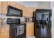 Close-up of kitchen featuring black appliances and light wood cabinets at 305 Terrace Ridge Cir # 305, Davenport, FL 33896