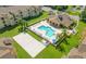 Aerial view of a community pool with lounge chairs and a sand volleyball court at 305 Terrace Ridge Cir # 305, Davenport, FL 33896