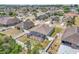 Aerial view displays a home with an enclosed screened lanai, set in a neighborhood with verdant trees and landscaping at 344 Highland Meadows St, Davenport, FL 33837
