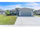 Charming single-story home featuring a manicured lawn, gray exterior paint, and a two-car garage at 344 Highland Meadows St, Davenport, FL 33837