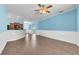Spacious living room with stylish wood floors, ceiling fan, and views to kitchen, dining, and entryway at 344 Highland Meadows St, Davenport, FL 33837
