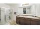 Bright bathroom featuring a double sink vanity, large mirror, and a glass-enclosed shower at 3679 Julius Estates Blvd, Winter Haven, FL 33881