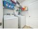 Well-lit laundry room with white washer and dryer units and wire shelving for storage at 3679 Julius Estates Blvd, Winter Haven, FL 33881