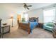 Comfortable bedroom boasts a wooden bed frame with blue bedding, natural light, and carpeted floors at 3679 Julius Estates Blvd, Winter Haven, FL 33881