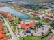Community aerial view showcasing a clubhouse, pool, lake, playground, and residential area with red tile roofs and landscaping at 4504 Alberto Cir, Kissimmee, FL 34746