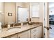 A well-lit bathroom features a granite countertop vanity and a large mirror adjacent to the kitchen at 4504 Alberto Cir, Kissimmee, FL 34746
