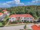 Beautifully landscaped condo building featuring a red tile roof and lush greenery at 4504 Alberto Cir, Kissimmee, FL 34746