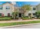 Inviting exterior view of a two-story townhome with neutral paint, a red tile roof, and manicured landscaping at 4504 Alberto Cir, Kissimmee, FL 34746