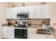 Modern kitchen with white cabinets, granite countertops, and stainless steel appliances at 4504 Alberto Cir, Kissimmee, FL 34746