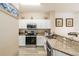 Bright kitchen featuring white cabinets, granite countertops, and stainless steel appliances at 4504 Alberto Cir, Kissimmee, FL 34746