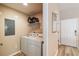 Bright laundry room featuring a side-by-side washer and dryer, wire shelving, and neutral wall color at 4504 Alberto Cir, Kissimmee, FL 34746