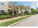 Street view showcasing a townhome with landscaped front yard, red tile roof, and neutral color scheme at 4504 Alberto Cir, Kissimmee, FL 34746