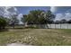 Large backyard featuring a well-maintained lawn, white fence, and mature trees for privacy and enjoyment at 459 Danube Dr, Poinciana, FL 34759