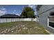 Backyard featuring a well-maintained lawn, white fence, gray exterior, and plenty of space for activities at 459 Danube Dr, Poinciana, FL 34759