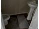 Small bathroom with pedestal sink, toilet, and uninstalled flooring, presenting an opportunity for customization at 459 Danube Dr, Poinciana, FL 34759
