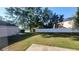 Spacious backyard with well-maintained grass, a white fence, and mature trees, creating a private outdoor oasis at 461 Fish Hawk Dr, Winter Haven, FL 33884