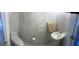 Elegant bathroom featuring marble tile walls, a modern toilet, and a sleek pedestal sink, creating a spa-like atmosphere at 461 Fish Hawk Dr, Winter Haven, FL 33884