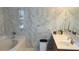 Bathroom with white marble tiling, white tub, and marble vanity at 461 Fish Hawk Dr, Winter Haven, FL 33884