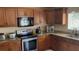 Kitchen features wooden cabinets, granite countertops, and stainless appliances at 461 Fish Hawk Dr, Winter Haven, FL 33884