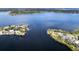 Beautiful aerial view featuring waterfront homes along the deep blue lake and lush green treeline at 6084 Masters Blvd, Orlando, FL 32819