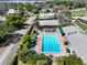 Aerial view of a community pool surrounded by lounge chairs and umbrellas, adjacent to lush landscaping and the building at 6084 Masters Blvd, Orlando, FL 32819