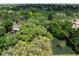Aerial view of a property with lush trees and landscaping bordered in yellow, near a pond at 6084 Masters Blvd, Orlando, FL 32819