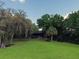 Spacious backyard featuring a lush lawn, mature trees, and a serene setting, perfect for relaxation and recreation at 6084 Masters Blvd, Orlando, FL 32819