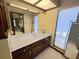 Bathroom featuring a white countertop, wood cabinets, and a mirror to the side at 6084 Masters Blvd, Orlando, FL 32819