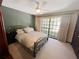 Carpeted bedroom featuring a ceiling fan, queen bed, and a large window with natural light at 6084 Masters Blvd, Orlando, FL 32819