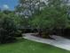 Charming home exterior with a long driveway, lush landscaping and a large mature tree in the center at 6084 Masters Blvd, Orlando, FL 32819