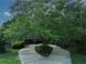 Charming home exterior with a long driveway, lush landscaping and a large tree in the center at 6084 Masters Blvd, Orlando, FL 32819
