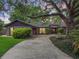 Charming home with mature trees, beautiful landscaping and a long driveway leading up to the front entrance at 6084 Masters Blvd, Orlando, FL 32819