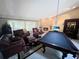 Spacious living room with a brick fireplace, comfortable leather seating, and a pool table for entertainment at 6084 Masters Blvd, Orlando, FL 32819