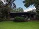 Charming home featuring a screened-in porch surrounded by lush greenery and a well-maintained lawn at 6084 Masters Blvd, Orlando, FL 32819